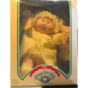 Cabbage Patch Kids 1985 Doll with blond hair, yellow sweater and one tooth sticking out by