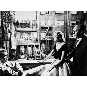 ALFRED HITCHCOCK AS MAN WINDING CLOCK IN SONGWRITER'S APARTMENT, GRACE KELLY AS LISA CAROL FREMONT, JAMES STEWART AS L. B. JEFFERIES FROM REAR WINDOW #1 - BLACK & WHITE Movie Photo - (4 Different Photograph & POSTER Sizes Available)