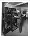 Historic Print (L): [J.B. Irwin operating the control panel of the Western Electric public address system at