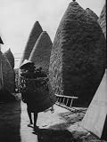 Native Wearing a Large Hat to Block the Sun is Walking Through Streets of Village Photographic Poster Print by Howard Sochurek, 30x40