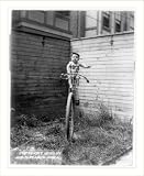 Historic Print (S): [Baby on large unicycle held up by ropes]