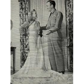 Starlet ELYSE KNOX tries on Hero TOMMY HARMON"S parachute for a wedding dress. Lieut. Tommy Harmon of U.S. Army Air Forces, twice chosen All-American when he played football at Michigan and twice last year given up for dead after plane crashes, came to Hollywood with the parachute he wore when shot down over China last October. Although the chute had bullet holes in it from Jap Zeros, Liuet. Harmon gave it to Elyse Knox, film starlet, to make into a wedding dress she will wear when she marries him this spring. ..... 1944 LIFE Magazine Picture, A4039A.