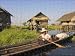 Photo Jigsaw 16x12 (40x30cm) Woman in canoe paddles past floating village by Robert Harding