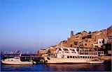 photographie Boats in old port with Tel Aviv in distance. est disperible en (L x H): 60 x 40 cm d... Image du produit