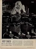 BUSY SINGER - Singer PEGGY LEE leans on a stack of records of her hit tune 