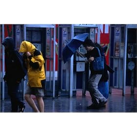 photographie Commuters make their way home during a force 8 typhoon hitting Hong Kong. est disper...
