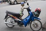 photographie Young motorcyclist with goggles on stationary motorcycle. est disperible en (L x H):...