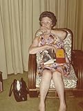 IMAGE OF Woman Sitting in a Chair With a Book on Her Lap and Her Hands Covering Her Mouth Photographic Poster Print, 30x40
