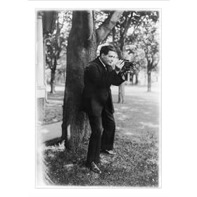 Historic Print (S): Renato Zanelle, baritone of the Metropolitan Opera, aiming a folding camera