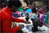 canvas Muslim man applying jewels and sequins with sewing machine at textile embroidery factory. ...
