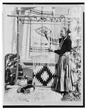 Historic Print (S): [Navajo Indian Na Glee Nona Ba (Peacemaker), weaving a rug on the patio of her home, Pal
