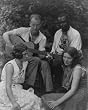 1906 photo Four musicians including a man playing a guitar, a man playing a violin, and two women se
