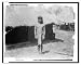 Historic Print (L): [Young man in traditional clothes beside thatch-roofed structure in Igorot village, Loui