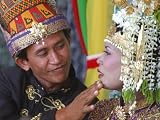 An Acehnese Bridegroom Cleans Face of His Bride During a Mass Wedding for Tsunami Victims Photographic Poster Print, 24x18