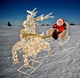 Weihnachtsmann mit Rentier und Schlitten, beleuchtet