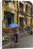 Canvas Prints of Man riding a bike and holding umbrella from Robert Harding