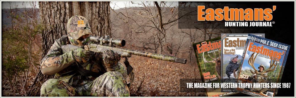 Hunter sitting next to tree with gun.  Eastmans' Journal Magazines